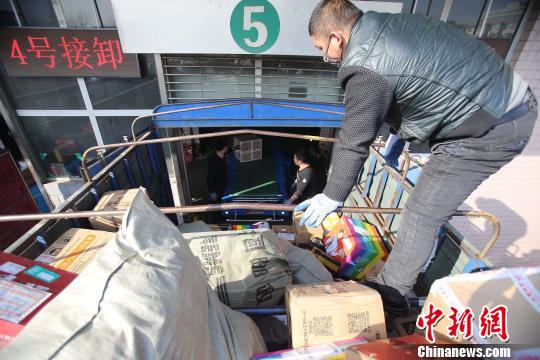 資料圖：工作人員正在給快遞包裹裝車。張?jiān)啤z